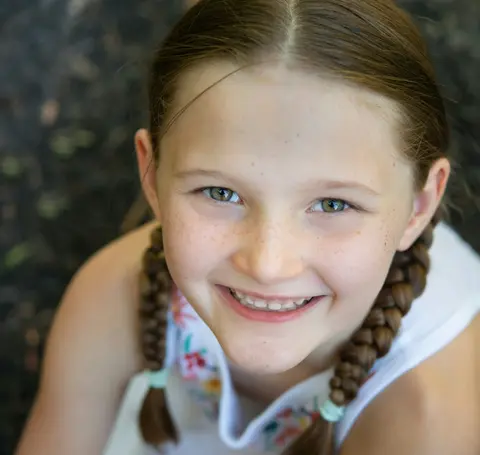 Child smiling in a portrait photo.